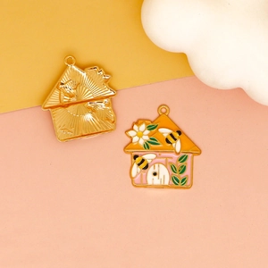 Detail of bee and flower enamel house charms showing gold metal back and colorful front