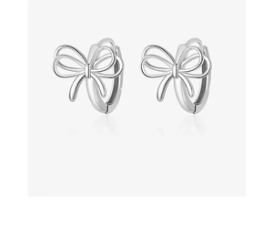 Detailed view of silver bow-shaped hoop earrings with polished metallic finish