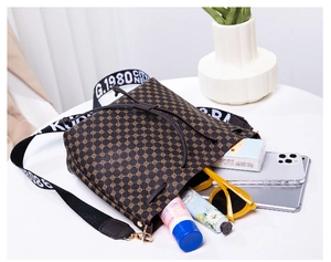 Detail view of printed bucket bag showing interior storage capacity and wide logo strap