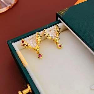 Details von vergoldeten Vintage-Ohrringen mit Blattstruktur und Zirkon in Geschenkbox