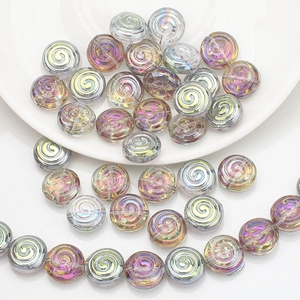 Macro shot of colorful spiral-textured crystal glass beads on a white ceramic plate