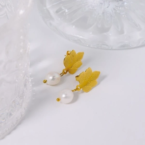 Elegant gold leaf earrings with round white pearls on a clean white background
