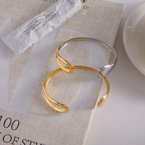 Minimalist two-tone open bangle set in gold and silver finish on artistic magazine base