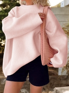Detail eines lockeren rosa Strickpullovers mit Rollkragen und langen Ärmeln im Freien