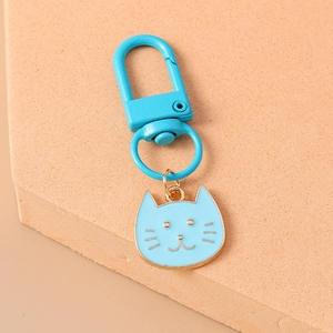 Close-up of a light blue enamel cat keychain with golden metal details and hook