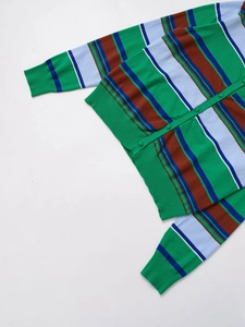 Detail showing colorful stripe knit texture with green ribbed edges and button closure