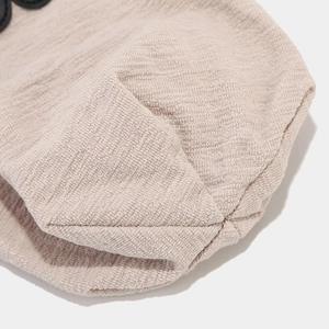 Macro shot of beige waffle knit fabric texture and small black circular decorative ears