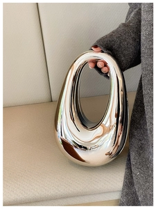 Close-up of a silver metallic organic sculptural handbag with a smooth mirror finish