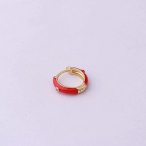 Detail of red enamel huggie hoop earring with clear stone on gold metal base