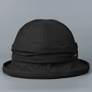 Detail view of a black linen bucket hat showing textured fabric and rolled brim