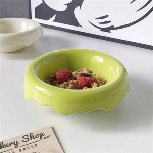 Nordic green ceramic bowl with wavy edges for breakfast cereal and fresh strawberries