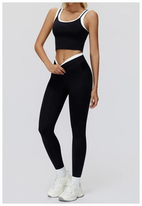 Detail of black high-waisted yoga leggings with white V-waistband layering effect