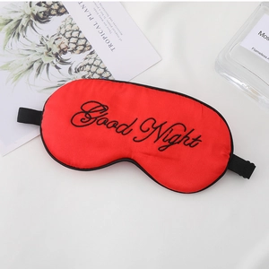 Detail of red faux silk sleep mask with Good Night embroidery and adjustable strap