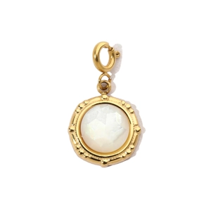 Detail of a round gold pendant with white gemstone and intricate beaded edge decoration