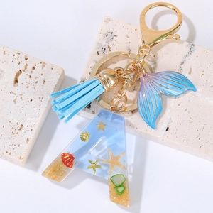 Detail of letter A keychain with resin ocean elements, shells, starfish and mermaid tail