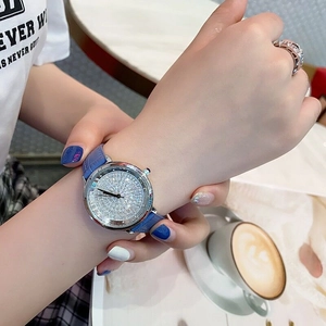 Close-up of a women's watch with a blue leather strap and crystal-encrusted dial