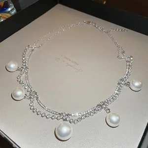 Double-layered necklace with sparkling diamond chain and five elegant white round pearls