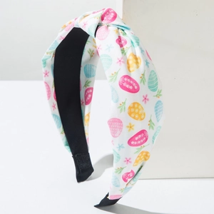 Detail of Easter knotted headband with colorful egg prints on white fabric textile