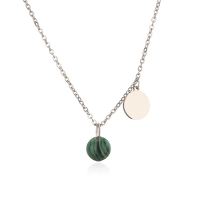 Macro view of silver tone chain with green malachite bead and polished circular pendant