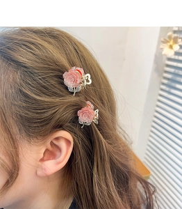 Pink glitter flower hair claw clips for girls, shown as a pair in a hair styling close-up