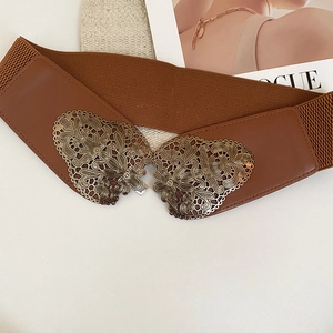 Gros plan d'une ceinture large élastique vintage avec boucle dorée ornée de fleurs