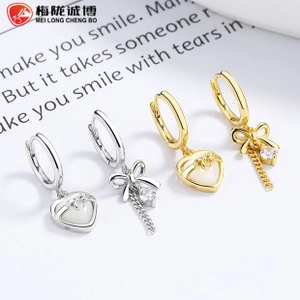 Close-up of 925 sterling silver heart earrings with bow design and zircon tassels