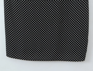 Close-up of black and white polka dot fabric showing the high-quality hem stitching detail