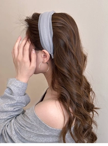 Detail of light blue-grey wide headband on brown wavy hair with soft fabric texture