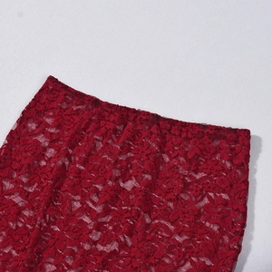 Détail de dentelle florale rouge foncé montrant les motifs délicats du tissu