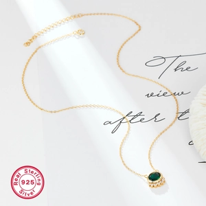 Close-up of 925 sterling silver gold necklace featuring a green oval zircon pendant