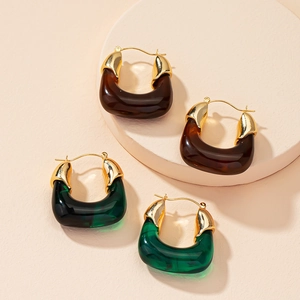 Detail view of retro geometric U-shape resin earrings in dark brown and emerald green