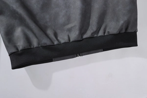 Makroaufnahme vom Saum der Herren-Lederjacke mit schwarzem Rippstrick und Metall-Reißverschluss