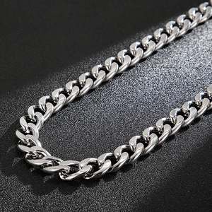 Macro detail of high-polished silver stainless steel Cuban link chain with glossy finish