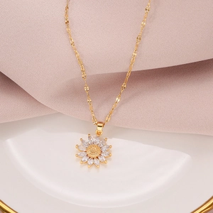 Vintage sunflower titanium steel necklace with sparkling crystal petals on a ceramic dish