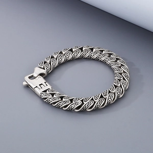 Detailed close-up of vintage silver titanium steel bracelet with engraved scroll patterns