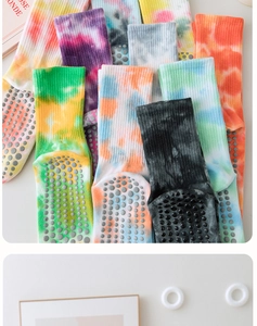 Close-up of tie-dye yoga socks showing anti-slip silicone grippers on the cotton sole