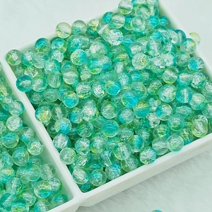 Detailed view of turquoise 6mm cracked glass beads in a tray for DIY jewelry making