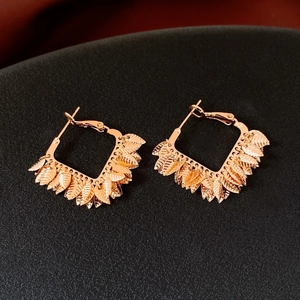 Close-up of 18K gold plated leaf charms and textured veins on rose gold hoop earrings