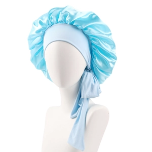Detail of light blue satin sleep bonnet featuring wide elastic headband and long ribbons