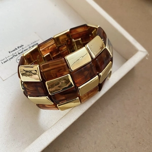 Dettaglio del bracciale a maglie in resina ambrata e metallo dorato in confezione