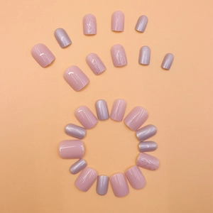 Short round press-on nails in pink and pearl purple colors with glitter accents
