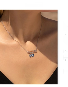 Detail of S925 sterling silver safety pin necklace with Hamsa hand and Evil Eye charms