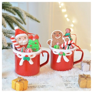 Detail of Santa and Gingerbread Man resin mugs with festive candy canes and warm lights