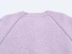 Detail of light purple knit sweater showing raglan sleeve seams and fine texture