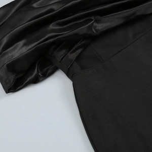 Close-up detail of black satin and matte fabric stitching on a sleek evening dress