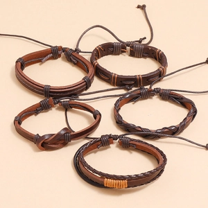 Detail of five-piece set brown leather bracelets featuring braided and layered designs