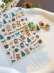 Close-up of 3D embossed Christmas bear and tree nail stickers in festive colors