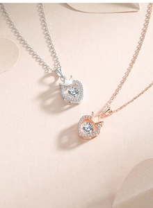 Detail view of silver and rose gold heart crown pendants with dancing zircon stones
