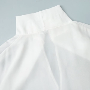 Detail shot of the stand-up collar and V-shaped back neck on white chiffon shirt