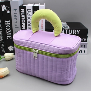 Quilted purple makeup bag with yellow handles and double zippers for large capacity storage